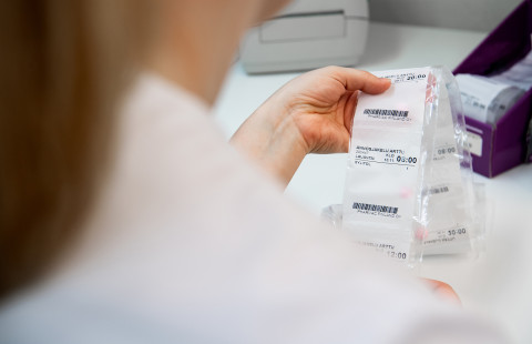 Apteekin työntekijä käsittelee annosjakelupusseja.