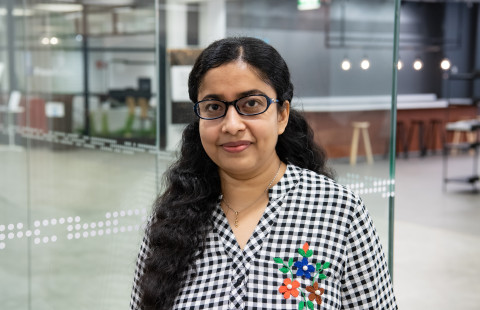 Women standing and smiling on campus