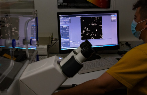 Man working with a microscope.