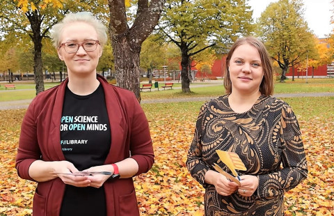 Kaksi kirjastoammattilaista syksyisessä puistossa.