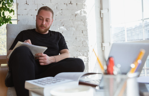 Mies opiskelee kotona.