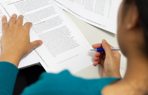 Nainen lukee artikkelia.