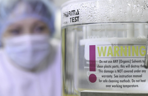 Henkilö tarkastelee lääkkeiden tesitilaitteistoa.