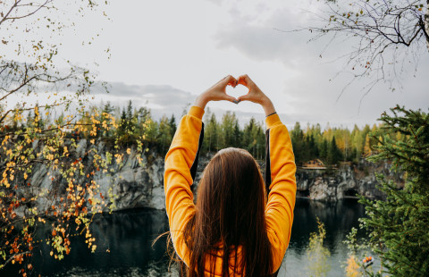 Nainen seisoo kanjonin reunalla.