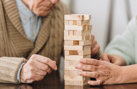 Kaksi ikäihmistä pelaa Huojuva torni -peliä.