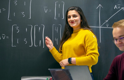 opiskelija liitutaulun edessä