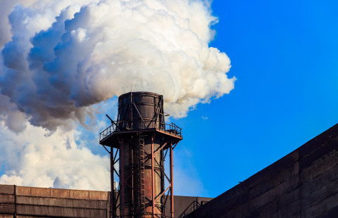 Flue gases come out from the factory chimney.