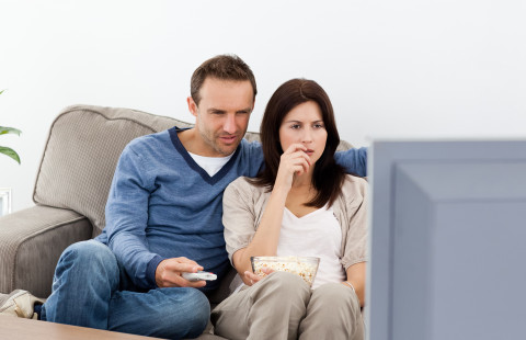 Couple watching something on the television.