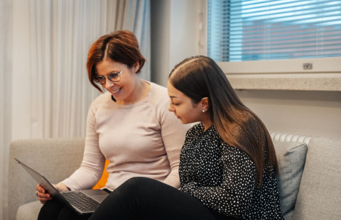 Opettajat keskustelevat keskenään tietokoneen äärellä.