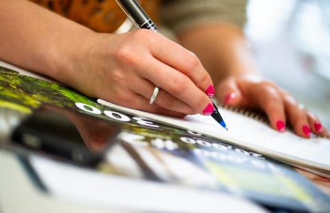 Nainen kirjoittaa muistiinpanoja.