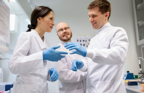 Tutkijoita näytteen ympärillä laboratoriossa.