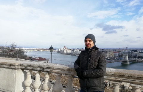 Student standing outside, on a bridge