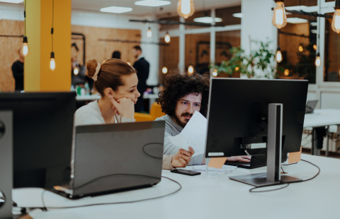 Kaksi henkilöä tietokoneella.