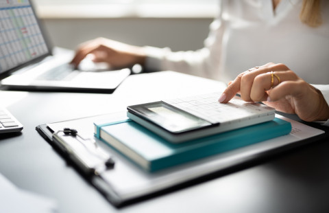 Kädet laskimella ja tietokoneella.