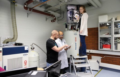 Farmasian laitoksen NMR-laitteen ääressä Petri Turhanen (vas.), Santosh Adla ja Tuulia Tynkkynen.