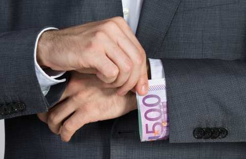 Käsi vetää seteliä hihansuusta.