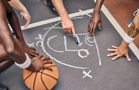 Asfalttiin piirretty koripallopelin taktiikkasuunnitelma.
