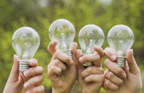 Neljä hehkulamppua neljässä kädessä.