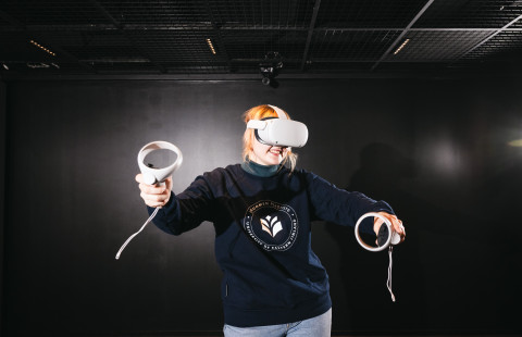 Nainen pelaamassa virtuaalitodellisuudessa.