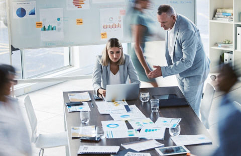 Ihmisiä neuvottelupöydän ääressä.