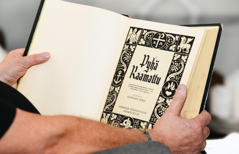 Henkilö lukemassa Raamattua.