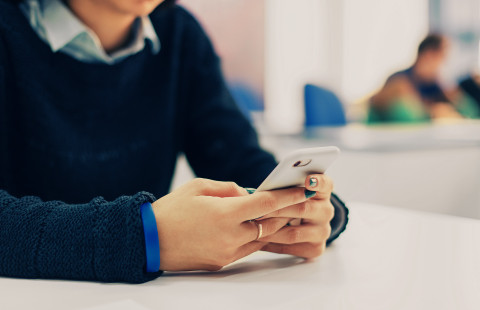Henkilö, joka näppäilee älypuhelinta.