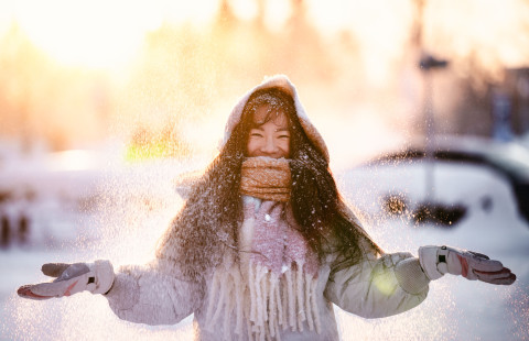 Student standing in snow and smiling