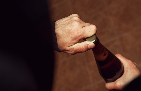 Hands and a beer bottle.