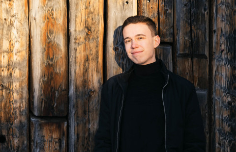 metsätieteen opiskelija Juho Lehtola Metla-talon hirsiseinustalla