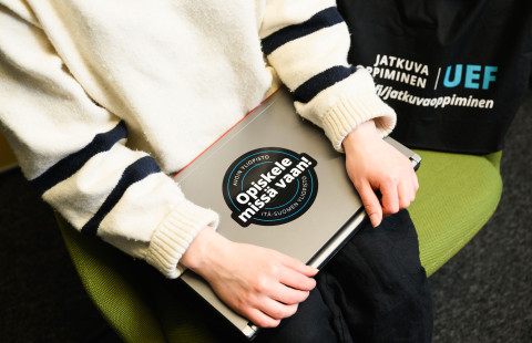 henkilö pitelee tietokonettaan sylissä