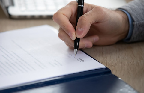 Lähikuva allekirjoittavasta kädestä.