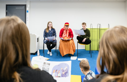 Elena Rapa, Maura Häkki ja Milla Tynnyrinen pitävät satutuntia kirjastolla.