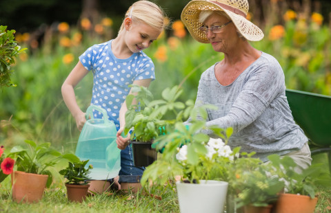 Lapsi ja vanhempi nainen puutarhatöissä.