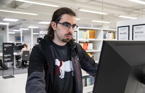 Opiskelija kirjastossa.