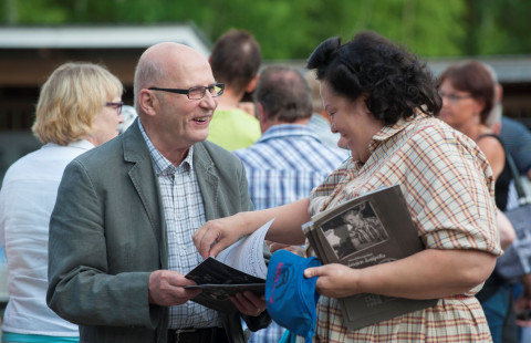 Kaksi henkilöä selaa esitettä.