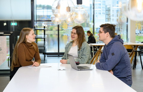 Opiskelijoita Snellmanian ala-aulassa pöydän ääressä