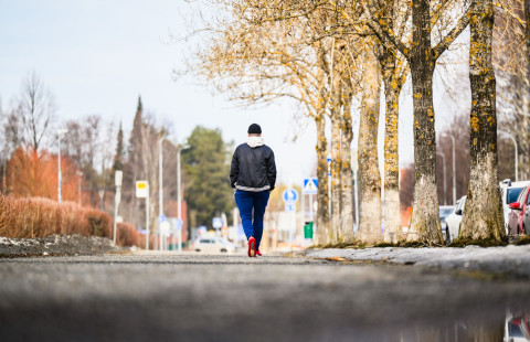 Henkilö kävelemässä yksin kadulla.