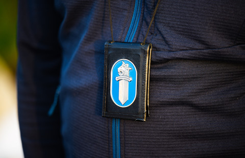 Poliisin lätkä kaulanauhassa.
