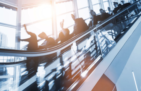 Ihmisiä liukuportaissa.