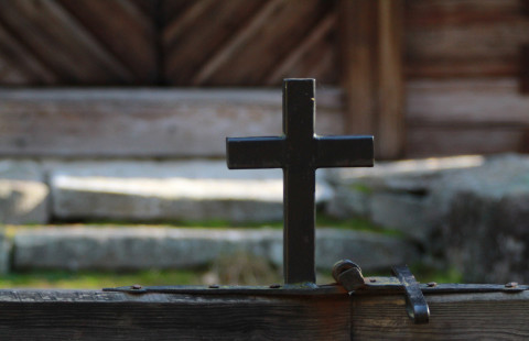 Vanha risti hirsitalon edessä.