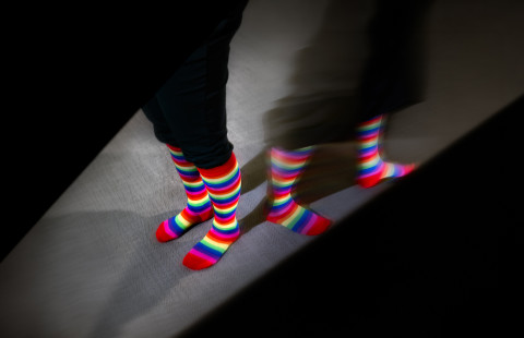 A picture of pride socks that diverge in different directions.