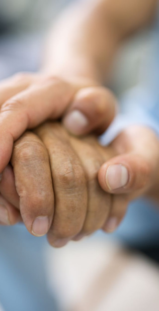 sairaanhoitaja pitää vanhusta kädestä