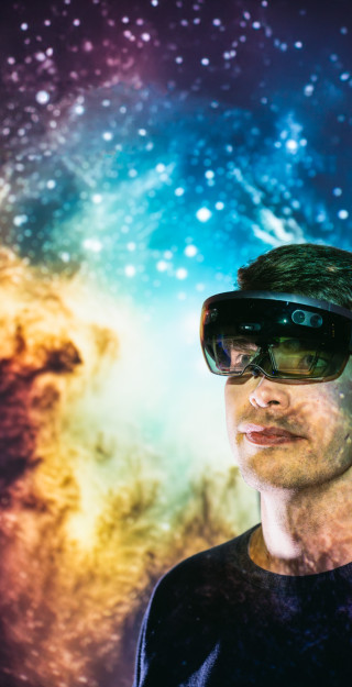 Tekniikan opiskelija ar-lasit päässä, taustalla kuva avaruudesta